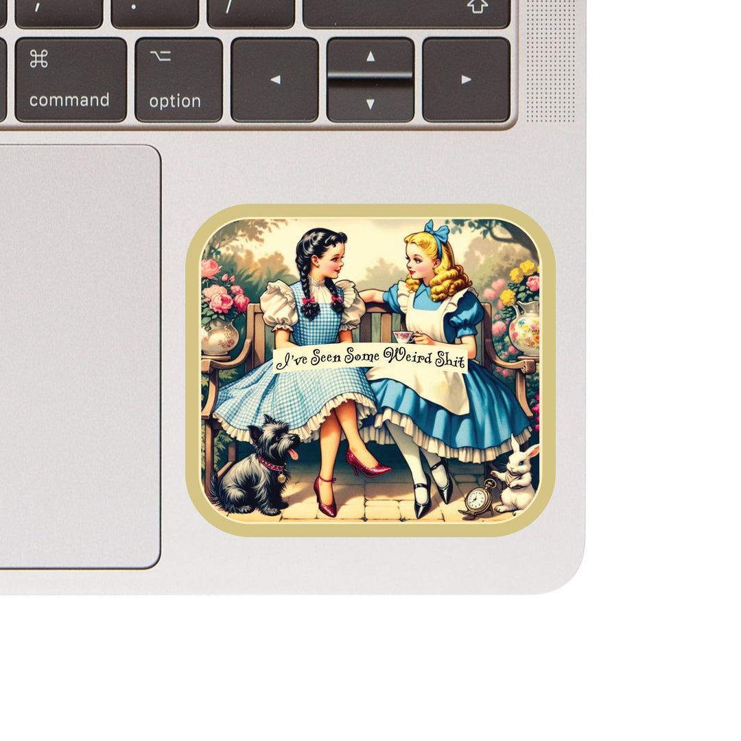 Laptop with a sticker of two characters from 'Alice in Wonderland' holding hands.