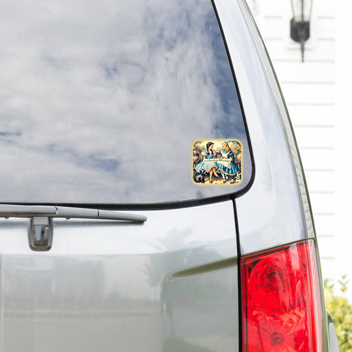Car with a decorative sticker on the rear window, featuring a scenic design.