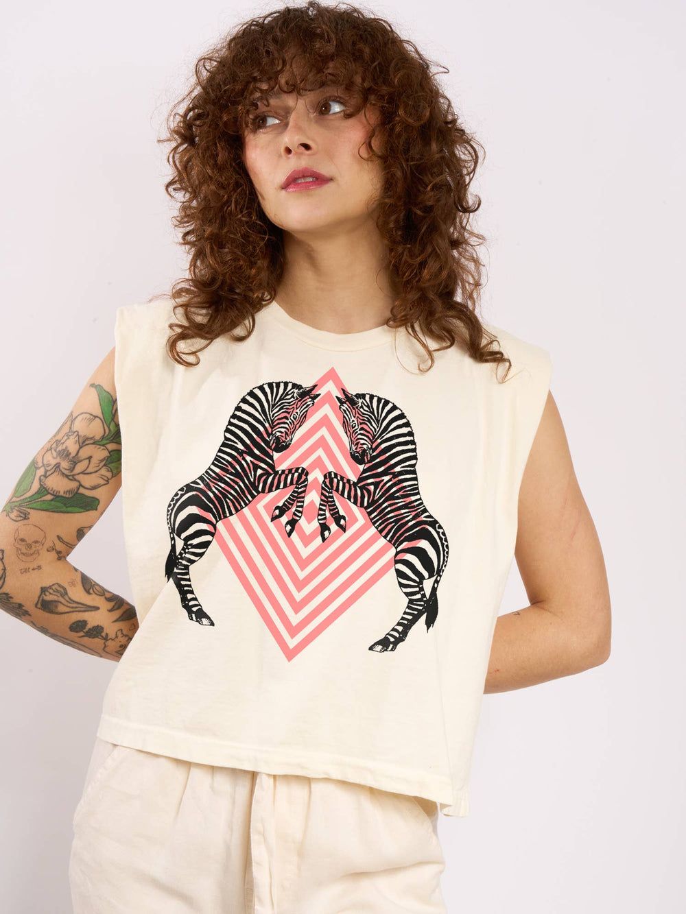 Person wearing a sleeveless top with a zebra design on a plain background